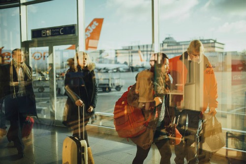 picture of travelers at the airport that should always consider getting travel insurance in case their flights are cancelled.